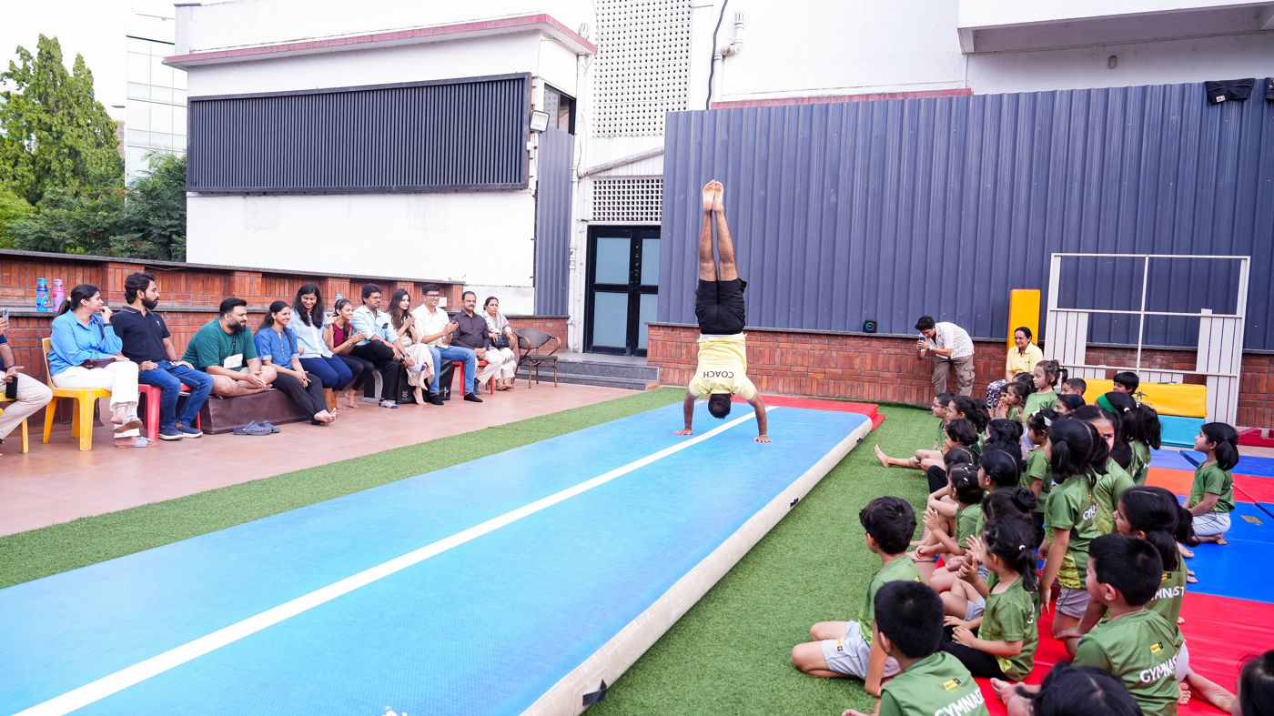 A young gymnast holding a handstand on the airtrack during a Sports+ session